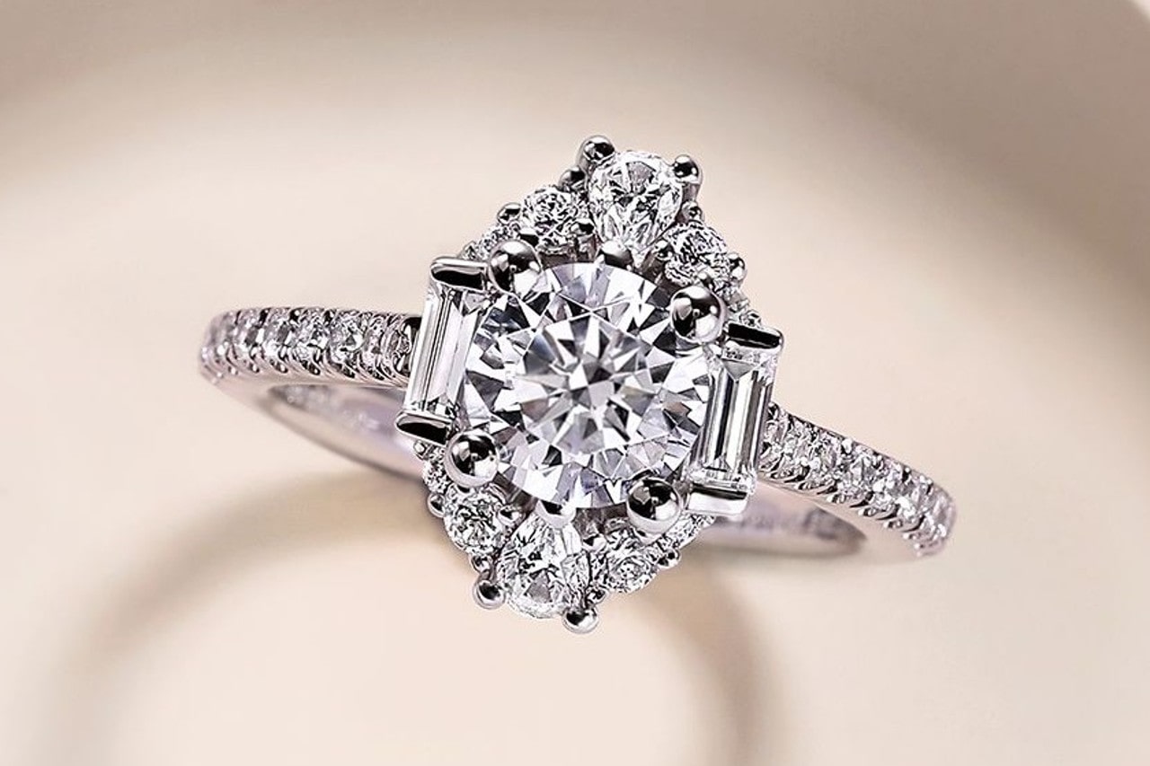 close up image of a white gold diamond engagement ring with side stones in a variety of shapes