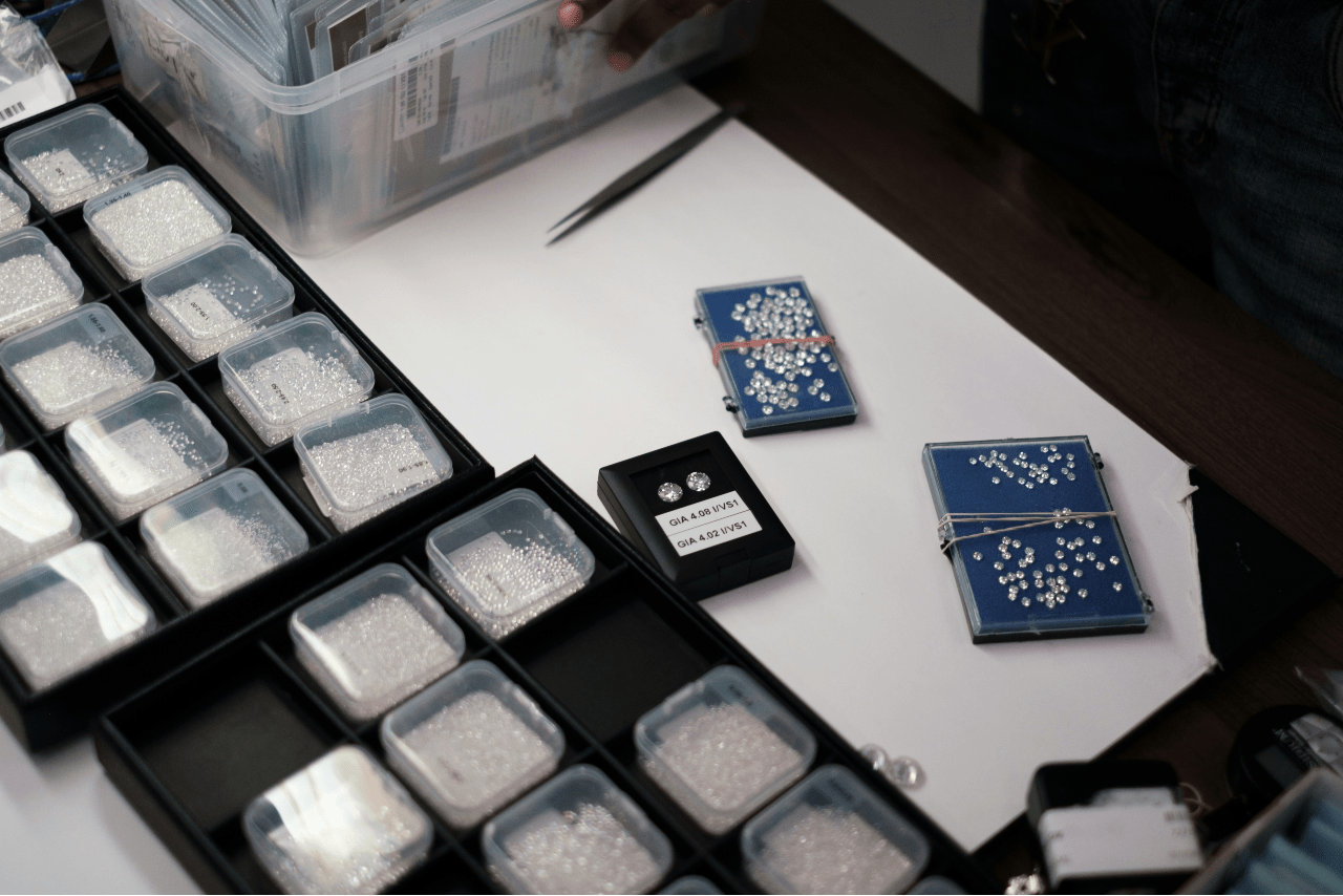 A top-down view of a wide selection of lab-grown diamonds, carefully organized into many small plastic containers.