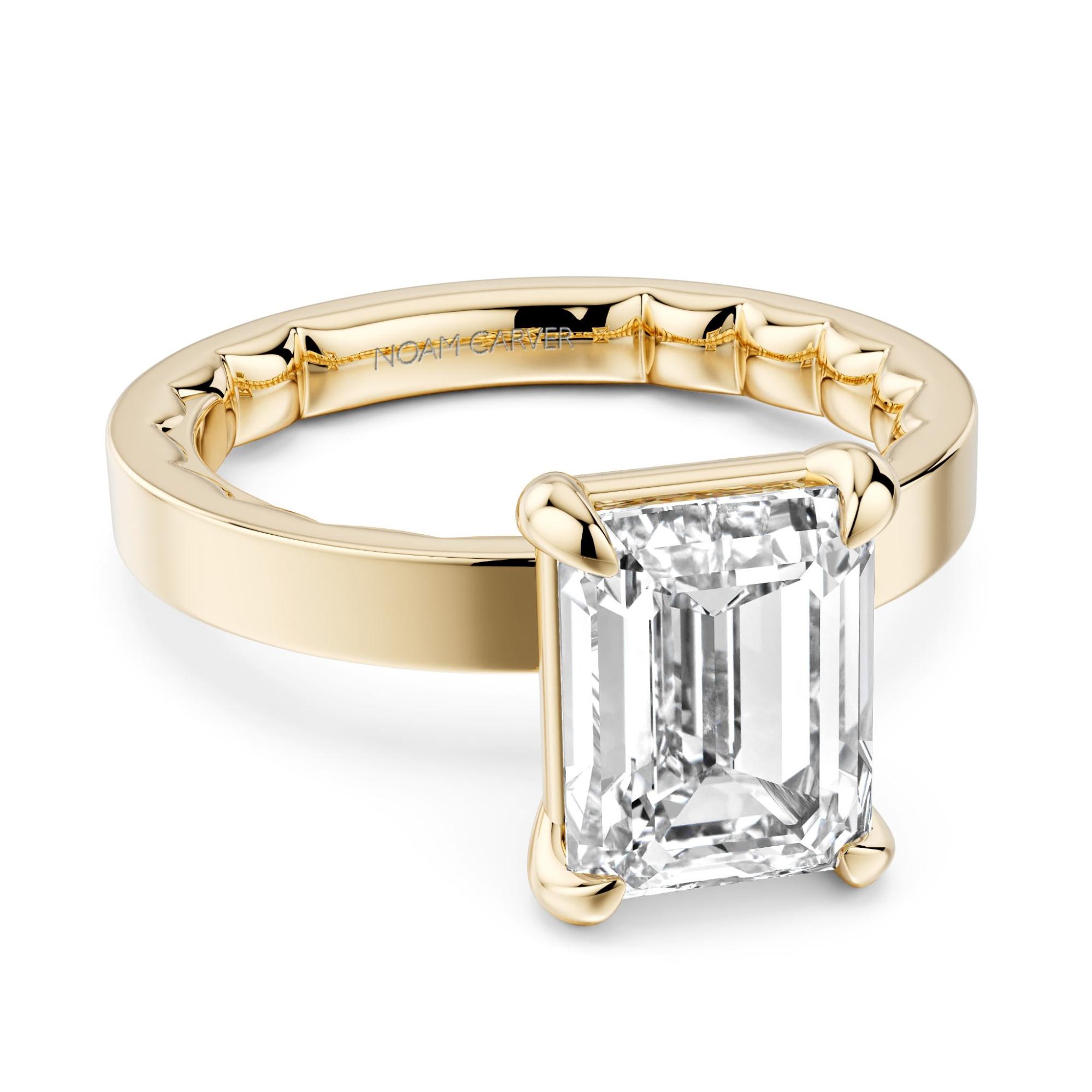 A yellow gold solitaire engagement ring with emerald cut center diamond
