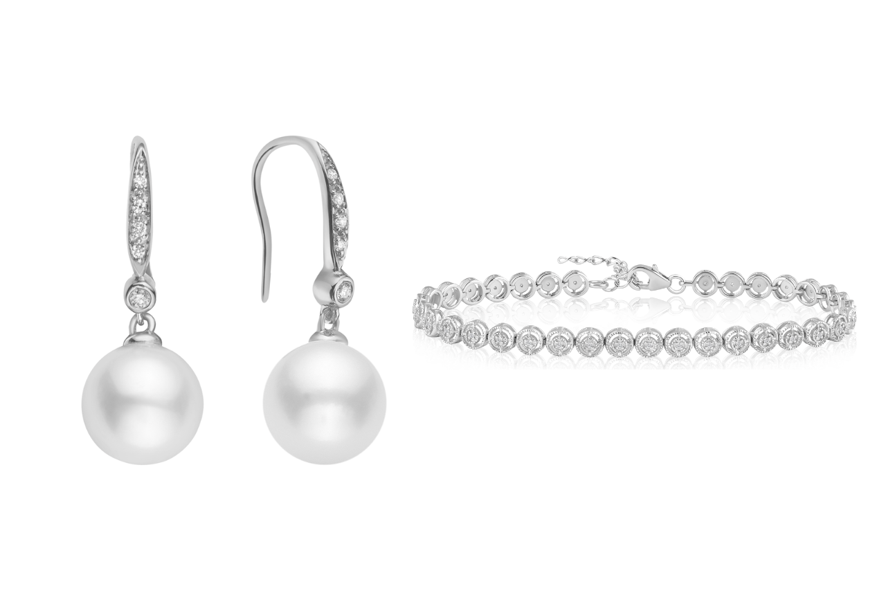 A pair of dangling pearl earrings with diamond accents, paired with a tennis bracelet with circular diamonds.