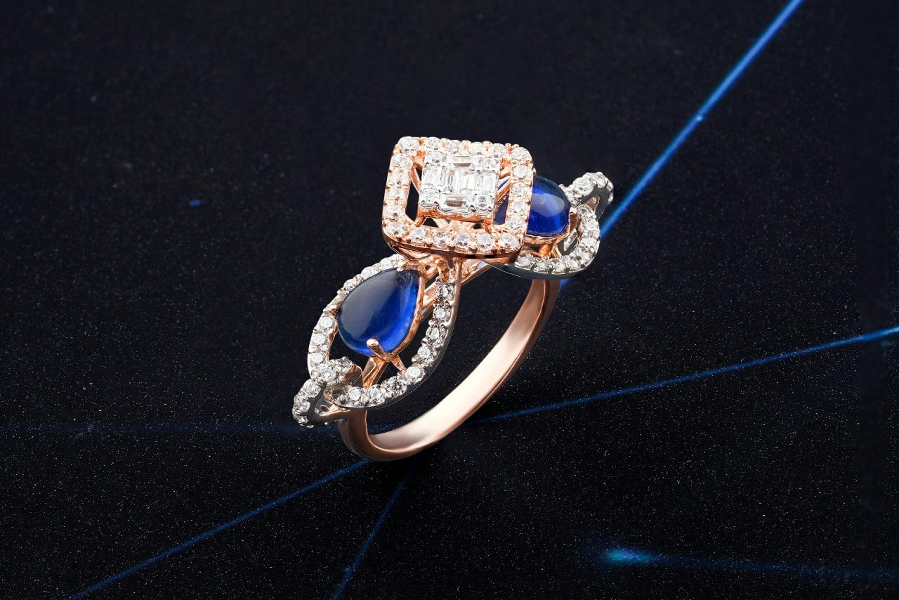 a rose gold engagement ring with blue side stones