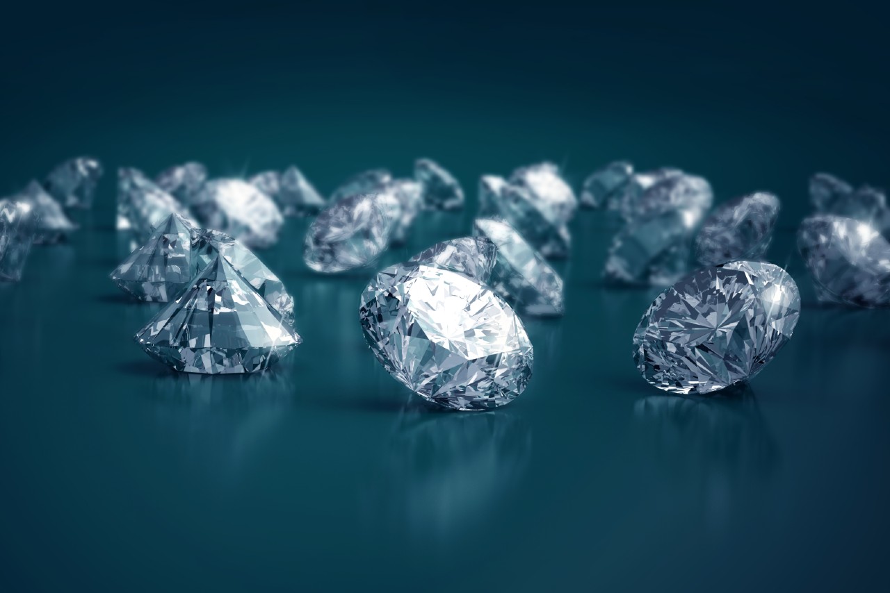 Scattered diamonds on a reflective surface against a dark teal background.