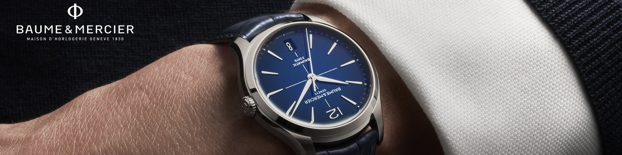 A hand with a watch on the wrist with text Baume and Mercier.