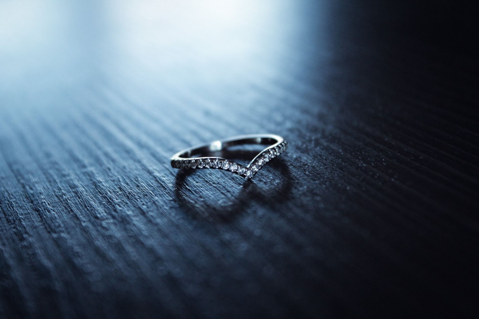 A wedding band covered in diamonds that has a V indent to set better against the center stone of an engagement ring A wedding band covered in diamonds that has a V indent to set better against the center stone of an engagement ring