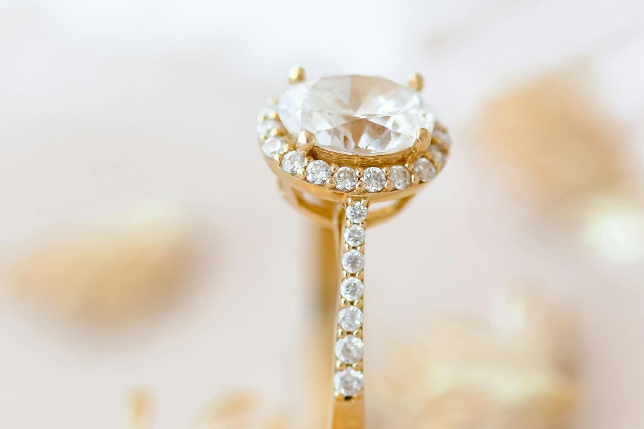 A close-up image of a yellow gold engagement ring with an oval cut engagement ring. A close-up image of a yellow gold engagement ring with an oval cut engagement ring.