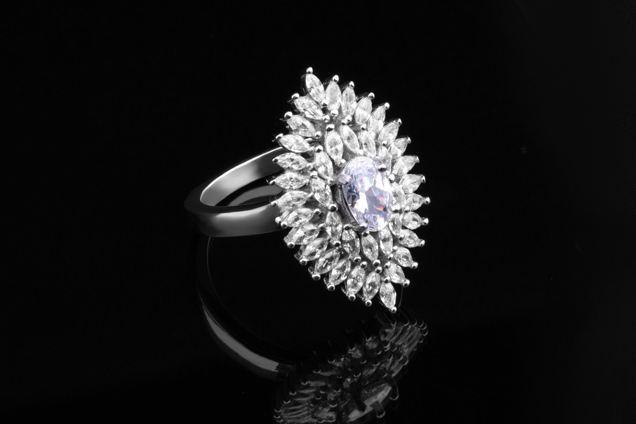 a diamond fashion ring featuring oval and marquise cut diamonds against a black background