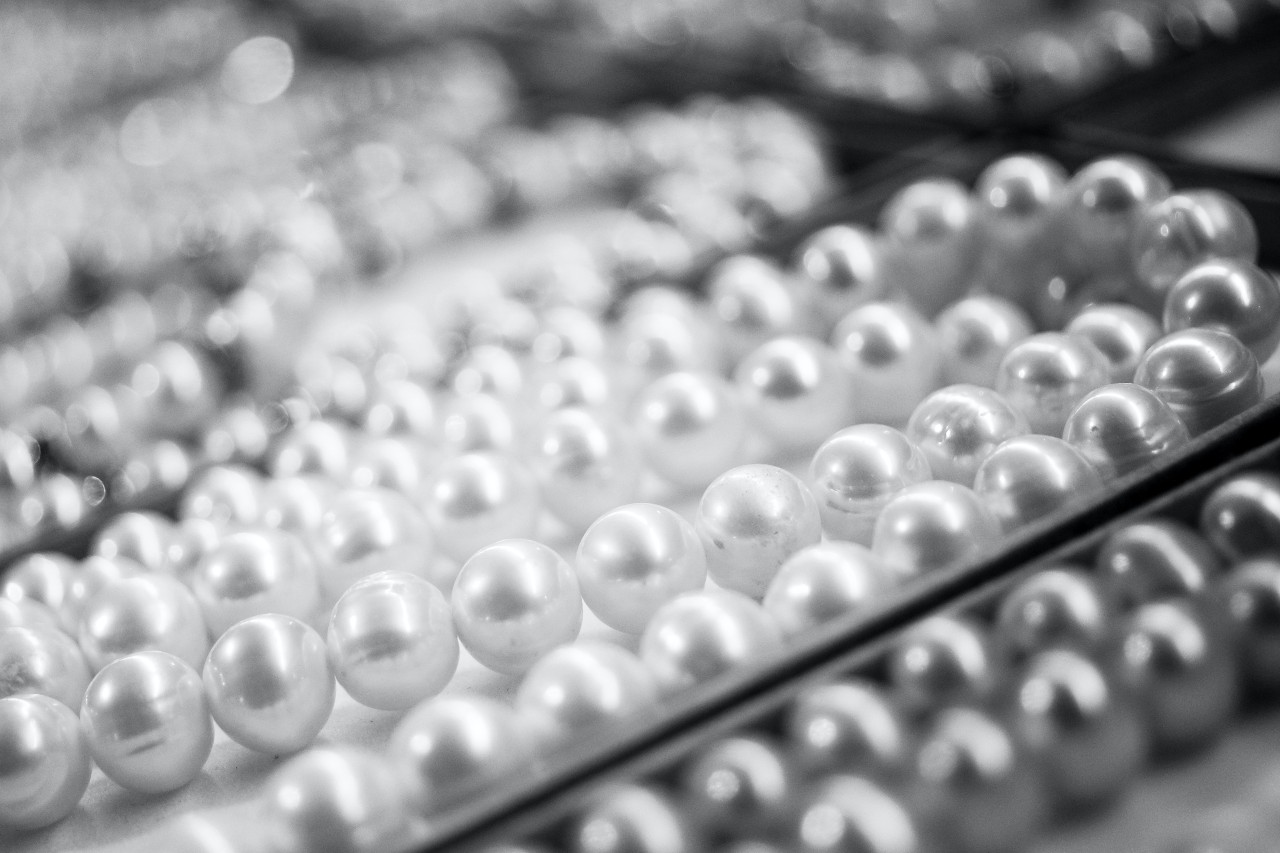 A black and white photo of multiple strings of pearls