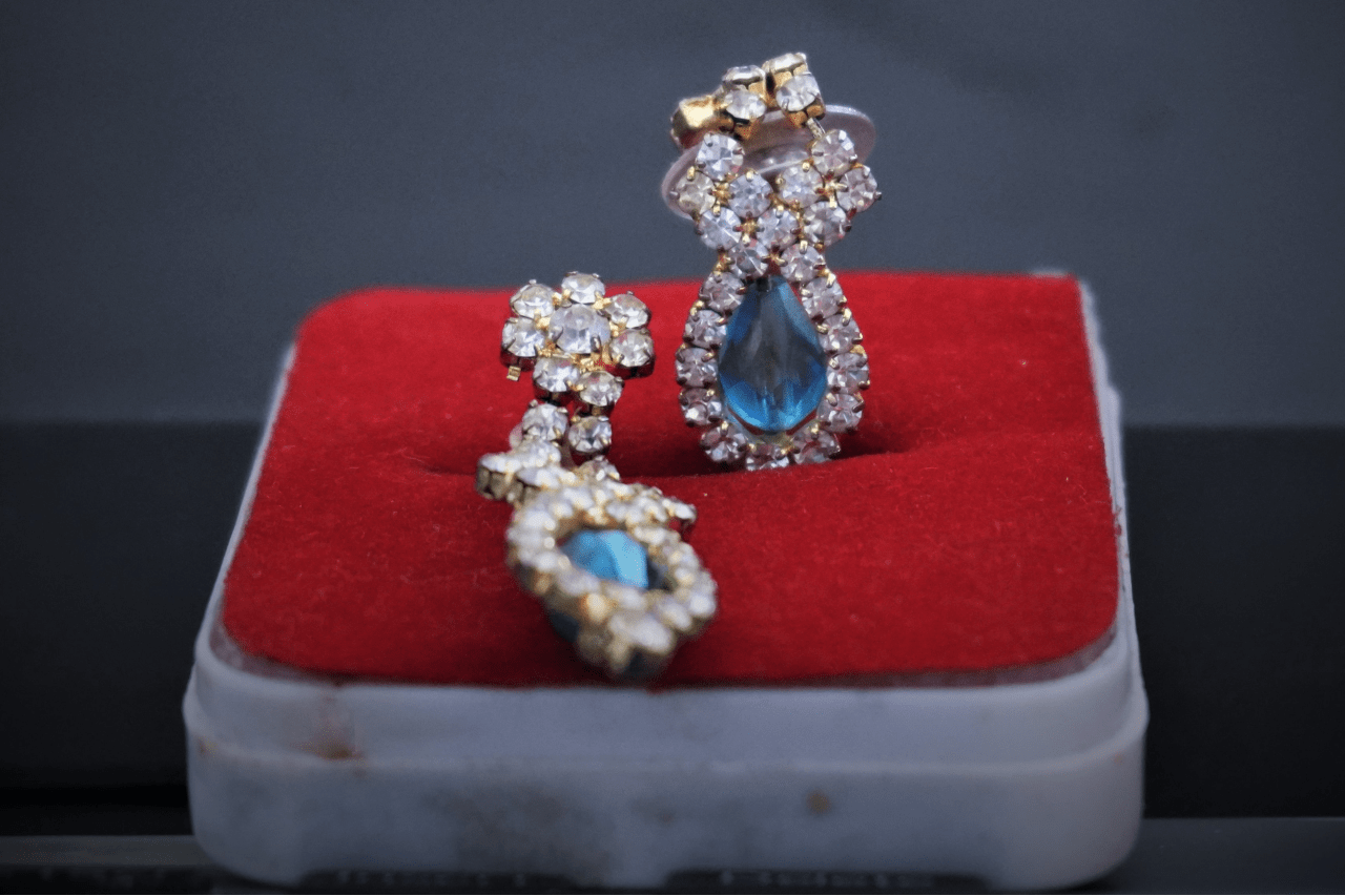 A pair of ornate yellow gold, diamond, and blue topaz drop earrings