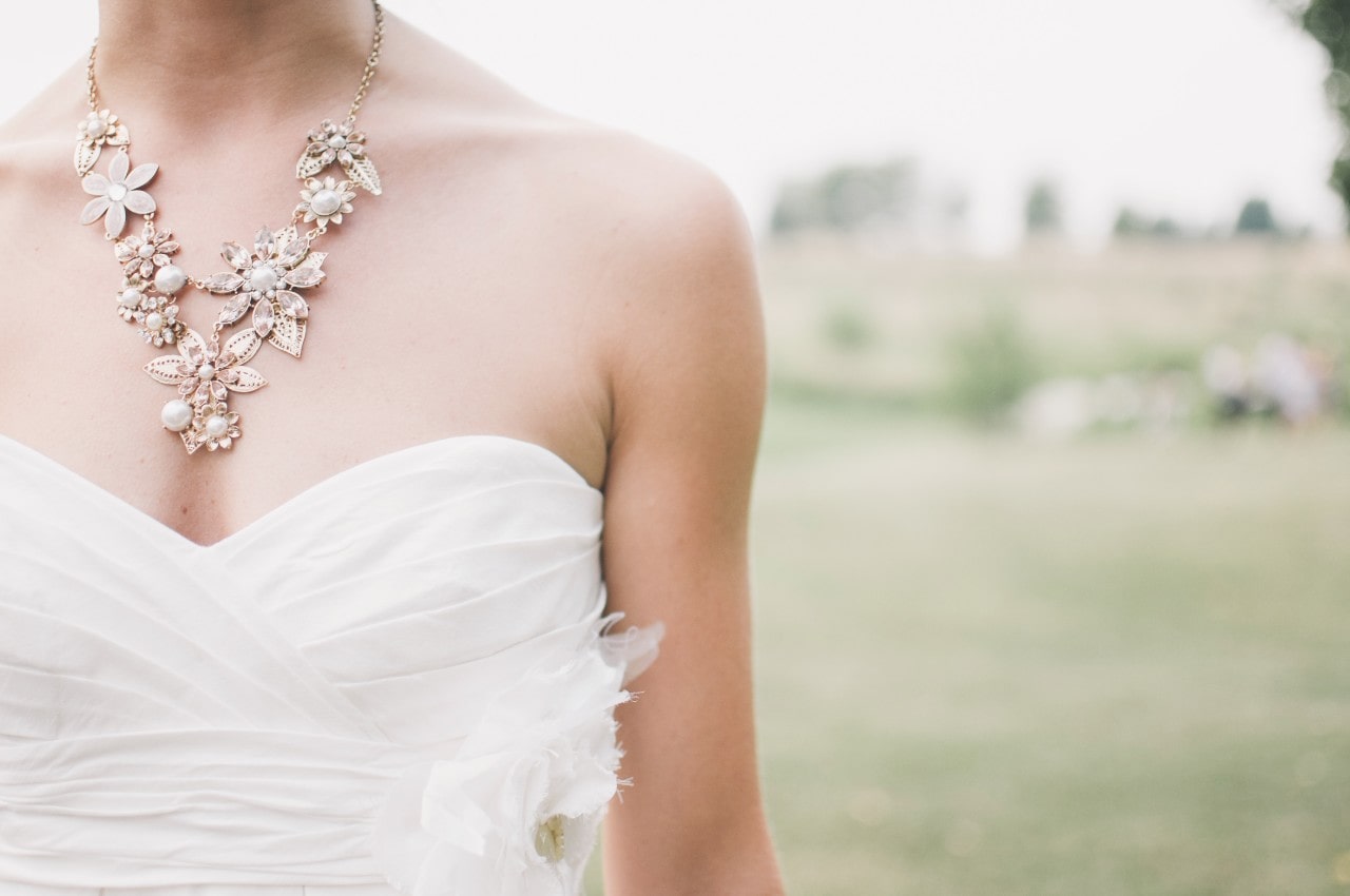 A spring bride wearing a floral pearl necklace with her strapless gown
