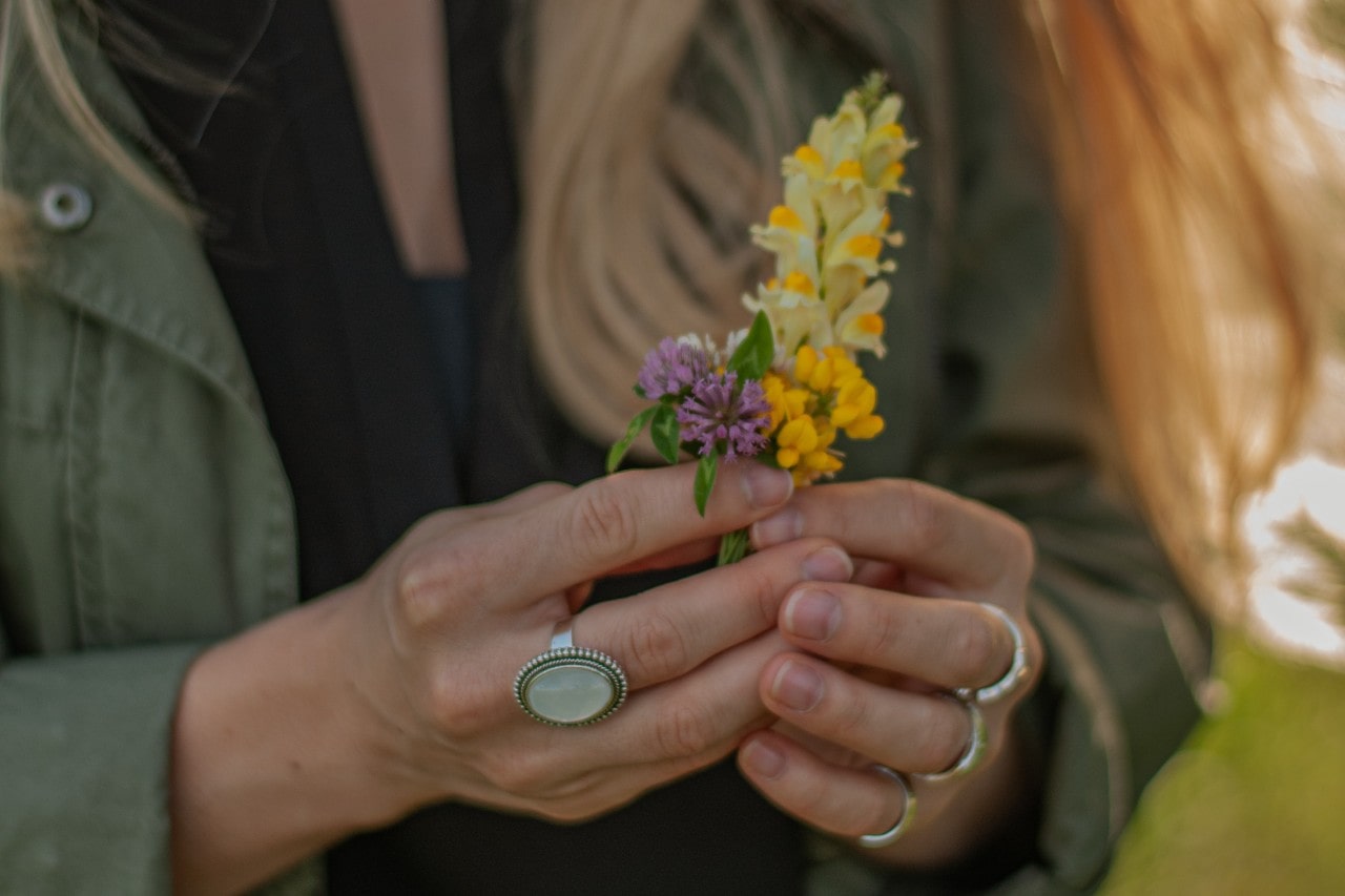 Spring-ready lady holding colorful flowers in her hands clad in fashion rings