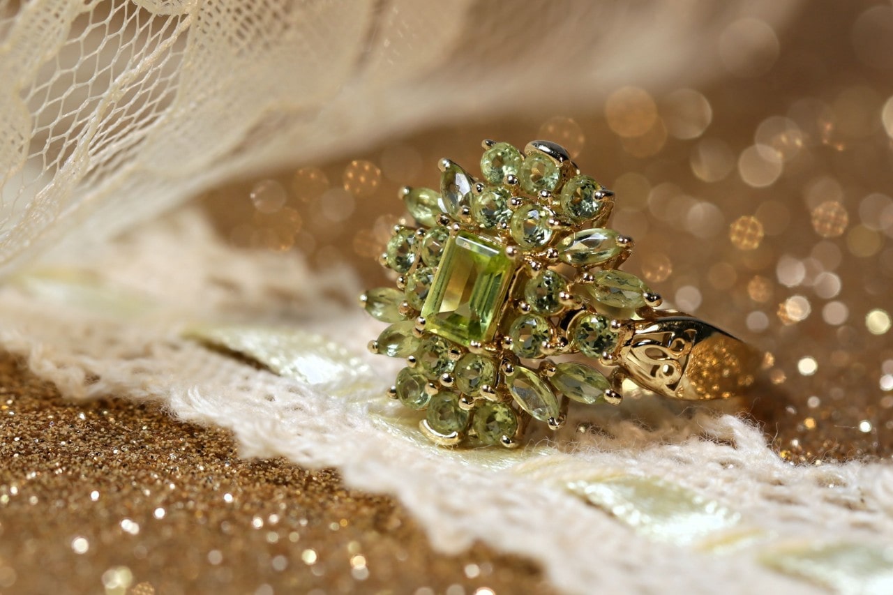 Peridot ring in a sparkling background