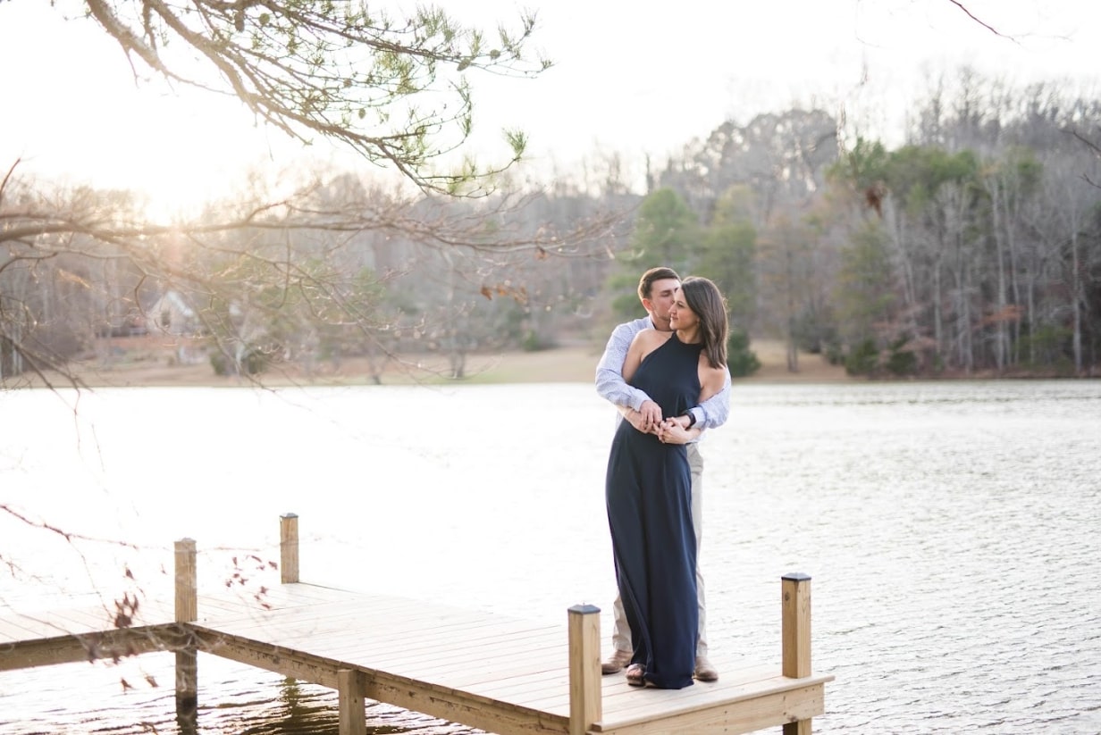 Romantic couple embracing on a pier over a lake