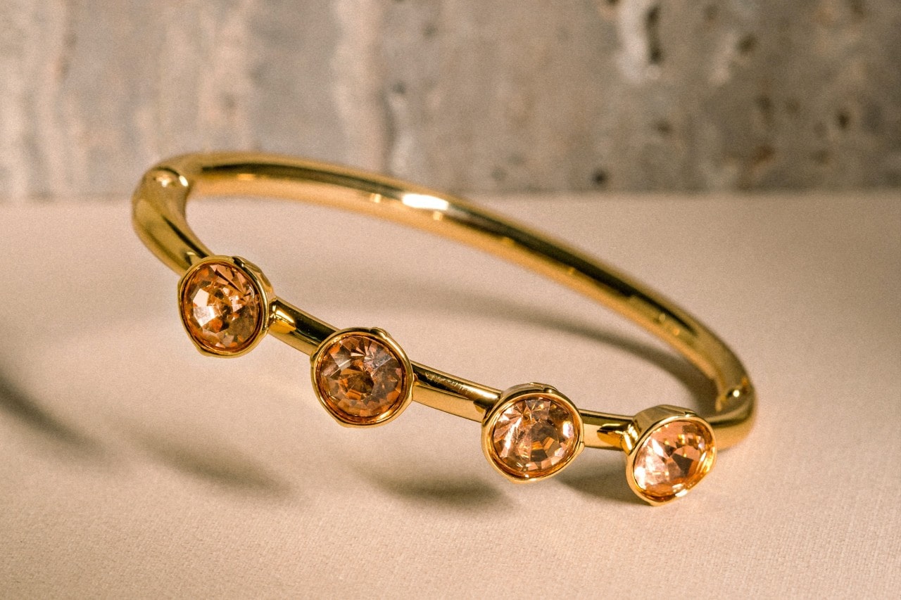 A gold fashion ring features four bezel-set citrine jewels.