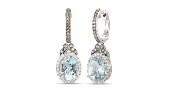 a pair of mixed metal drop earrings featuring a blue center stone and accent diamonds