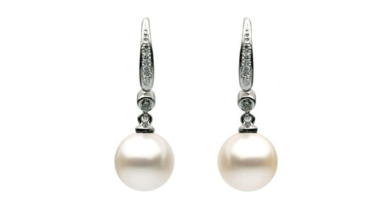 a pair of white gold drop earrings featuring stunning pearls and diamond accents