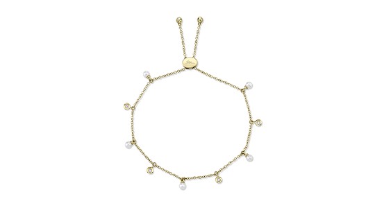 a yellow gold station bracelet featuring alternating pearls and diamonds